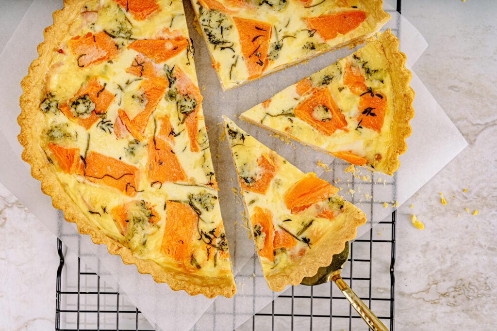 Top view of a delicious pumpkin quiche with herbs, perfect for autumn meals.